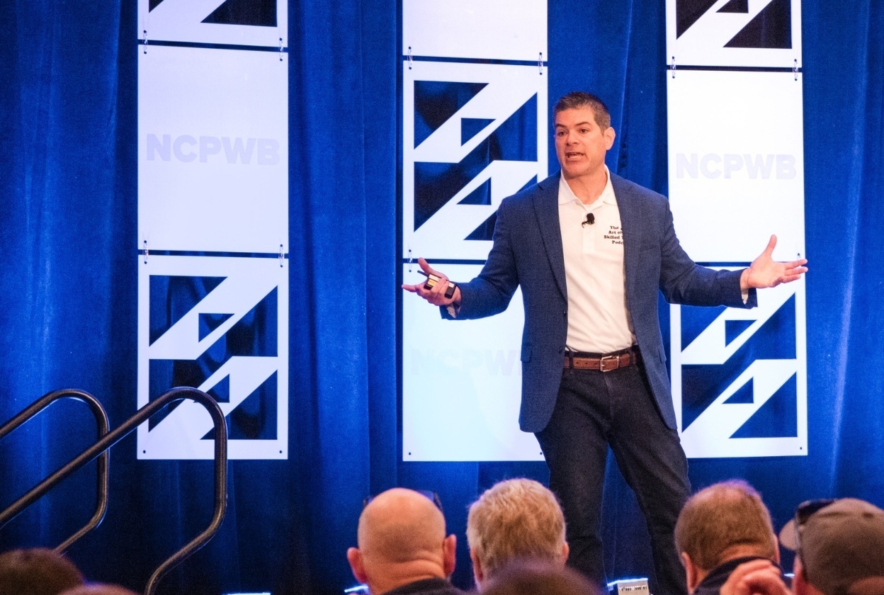 Andrew Brown speaking on stage to a skilled trades audience